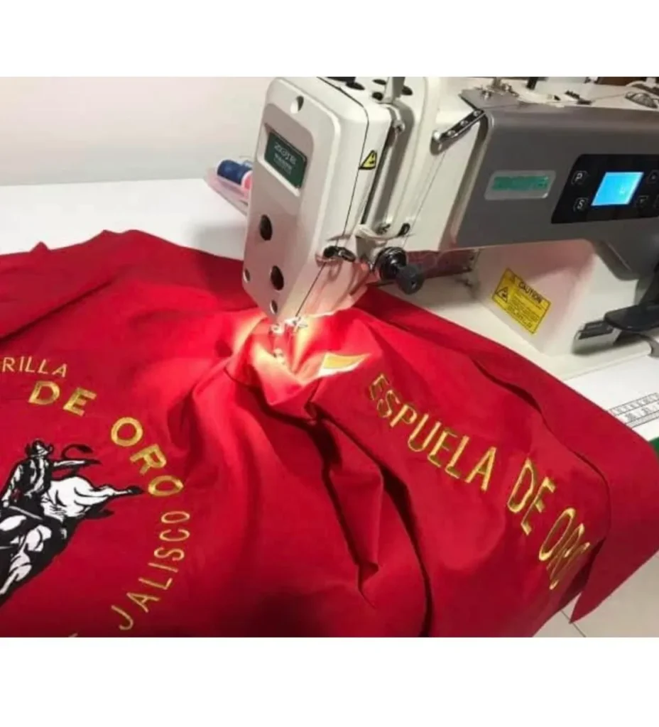 Confeccionando una camisas vaquera para cabalgatas en color rojo sobre la base de una maquina de coser