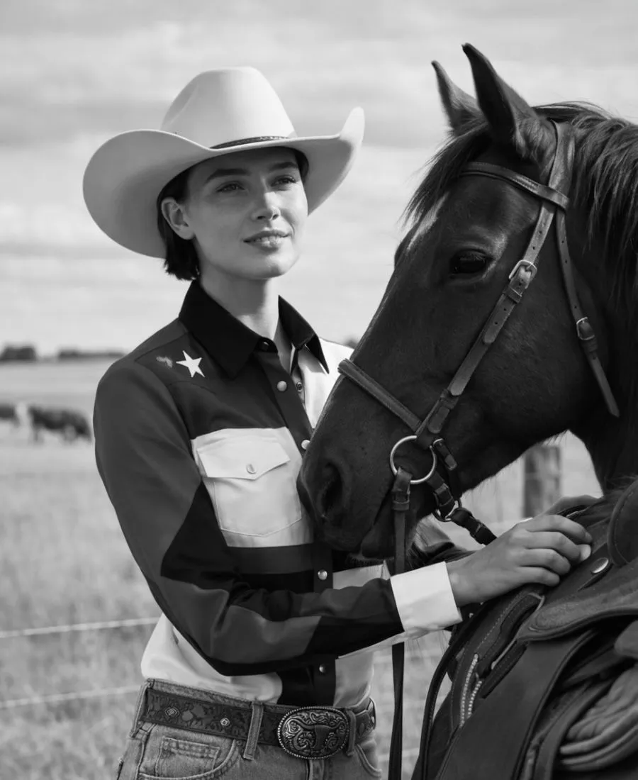 una vaquera joven alista su caballo para montarlo